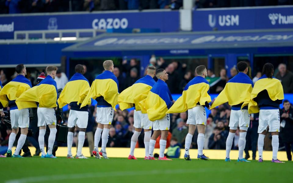 Everton's players draped in Ukrainian flags - A year on, this picture remains one of the most poignant sights in football - AP/Jon Super