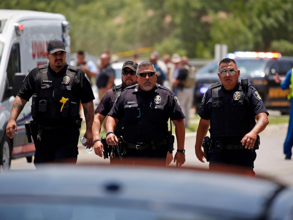 Police walk near Robb Elementary School following a shooting, Tuesday, May 24, 2022, in Uvalde, Texas.