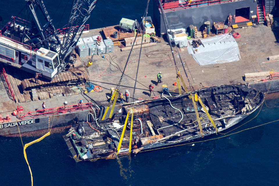 The burned hull of the Conception is brought to the surface by a salvage team, Thursday, Sept. 12, 2019, off Santa Cruz Island, Calif., in the Santa Barbara Channel in Southern California The vessel burned and sank on Sept. 2, taking the lives of 34 people aboard. Five survived. (Brian van der Brug/Los Angeles Times via AP)