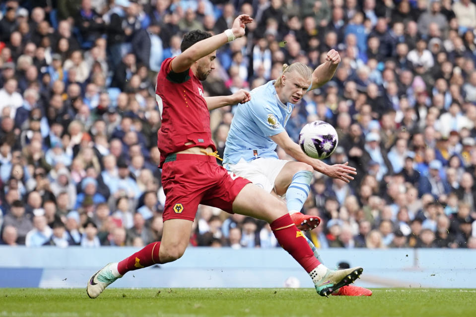 Manchester City's Erling Haaland, right, scores his side's fourth goal during the English Premier League soccer match between Manchester City and Wolverhampton Wanderers at the Etihad Stadium in Manchester, England, Saturday, May 4, 2024. (AP Photo/Dave Thompson)