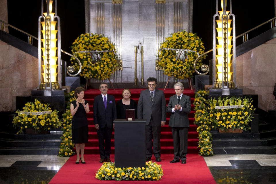 Mercedes Barcha, center, widow of Colombian Nobel Literature laureate, Gabriel Garcia Marquez, and sons Gonzalo Garcia, second from left, and Rodrigo Garcia, second from right, stand beside a box containing his remains, at a memorial service for the author at the Palace of Fine Arts in Mexico City, Monday, April 21, 2014. At right is Rafael Tovar y de Teresa, director of Mexico's National Council for the Arts and Culture. Woman at left is unidentified. (AP Photo/Rebecca Blackwell)