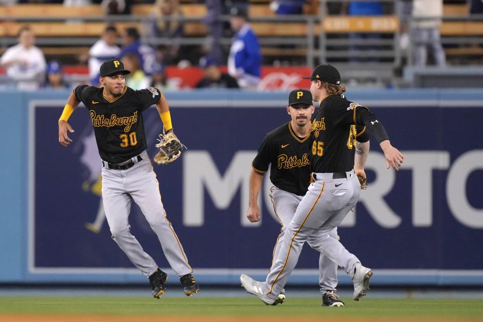 May 31, 2022; Los Angeles, California, USA; Pittsburgh Pirates left fielder Tucupita Marcano (30), right fielder Jack Suwinski (65), and center fielder Bryan Reynolds (10) celebrate after the game against the Los Angeles Dodgers at Dodger Stadium.