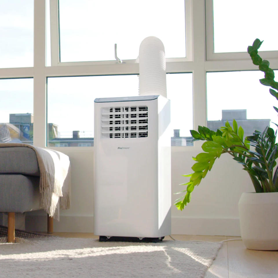 A portable air conditioner being vented out of a window