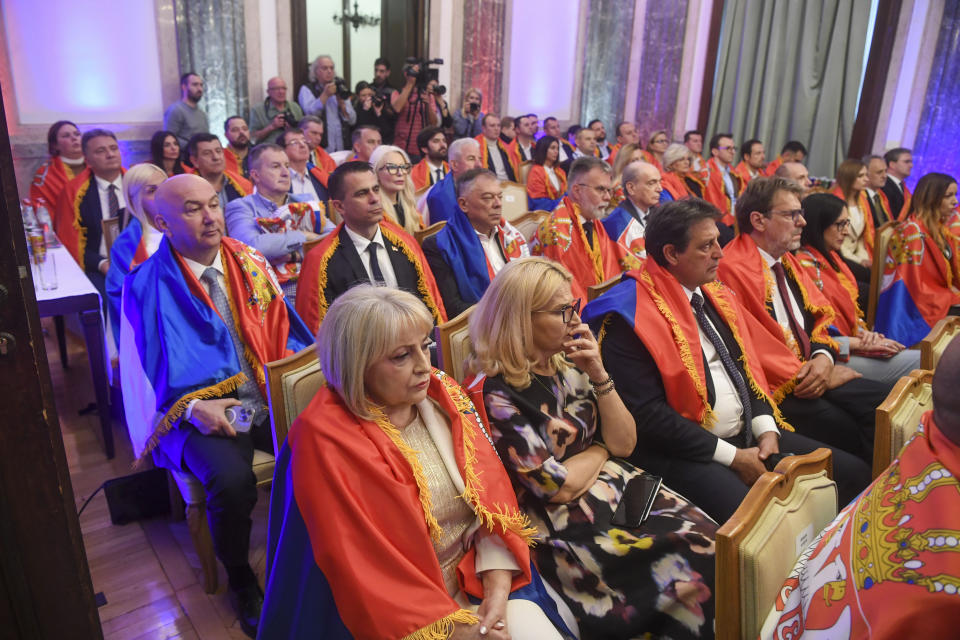 In this photo provided by the Serbian Presidential Press Service, Members of Serbia's government wrapped in Serbian flags as they watch the vote in the U.N. that established an annual commemoration of the 1995 genocide of Bosnia's Muslims by the Bosnian Serbs in Belgrade, Serbia, Thursday, May 23, 2024. (Serbian Presidential Press Service via AP)