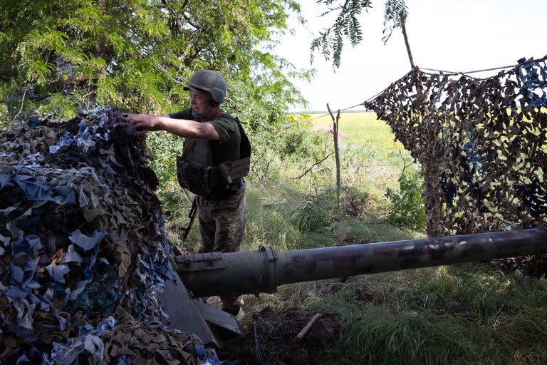 Un soldado ucraniano cubre su envejecido arma antitanque de artillería con camuflaje justo al nordeste de la ciudad ocupada por Rusia de Kherson, Ucrania, el sábado, 4 de junio de 2022. Capacitar a los soldados sobre cómo usar equipos más nuevos, suministrados por Occidente, se ha convertido en un importante obstáculo. (Tyler Hicks/The New York Times)