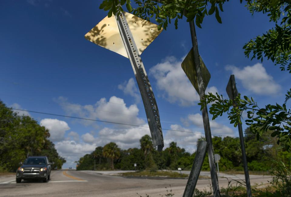 A damaged road sign is seen at the intersection of Indian River Drive at the end of Walton Road on Monday, May 17, 2021, in Port St. Lucie. On Saturday, May 15, a woman died after her 2005 Toyota sedan crashed into a 2010 Chevrolet sedan at the stop sign on Walton Road, sending both vehicles across Indian River Drive and down a 30-foot embankment into the Indian River Lagoon. 