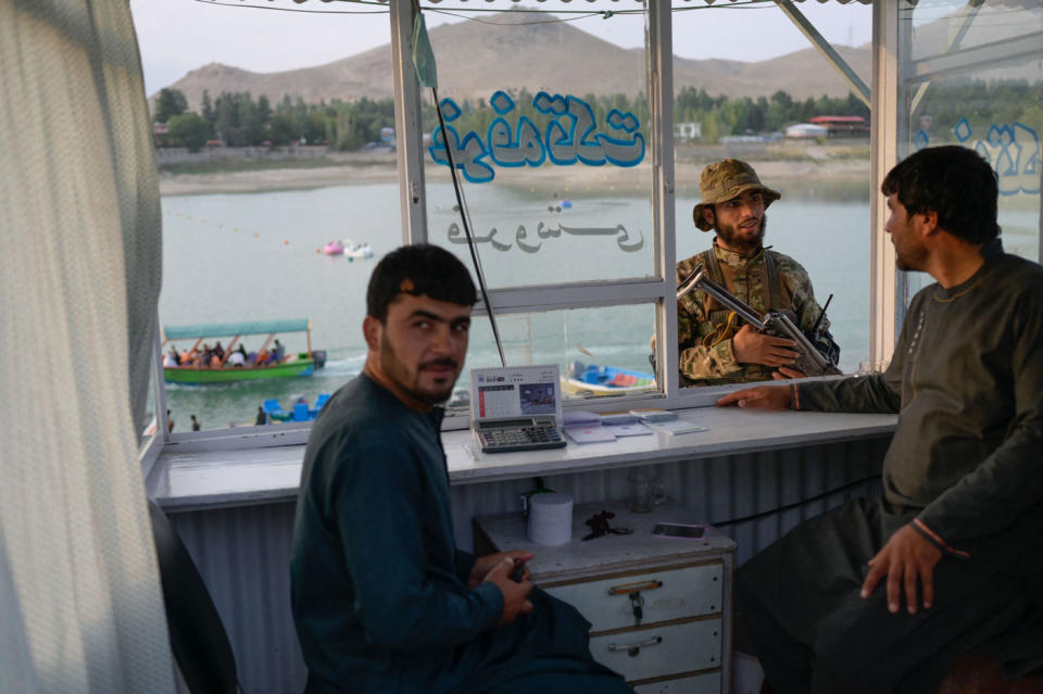A Taliban member (middle) speaks with shop owners at Qargha Reservoir on the outskirts of Kabul on September 19. Source: Getty Images
