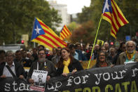 People, waving Estelada pro Catalonia independence flags, march during a protest in Brussels, Tuesday, Oct. 15, 2019. New disruptions to Catalonia's transportation network on Tuesday followed a night of clashes between activists and police over the conviction of separatist leaders, as Spanish authorities announced an investigation into the group organizing the protests. (AP Photo/Francisco Seco)