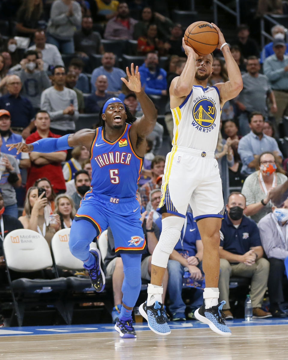 Golden State Warriors guard Stephen Curry (30) shoots in front of Oklahoma City Thunder forward Luguentz Dort (5) in the first half of an NBA basketball game Tuesday, Oct. 26, 2021, in Oklahoma City. (AP Photo/Nate Billings)