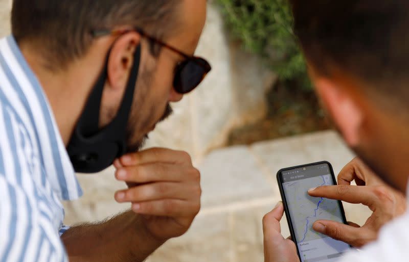 Palestinian cyclist Amer Kurdi uses a navigation app on his mobile phone in Ramallah in the Israeli-occupied West Bank