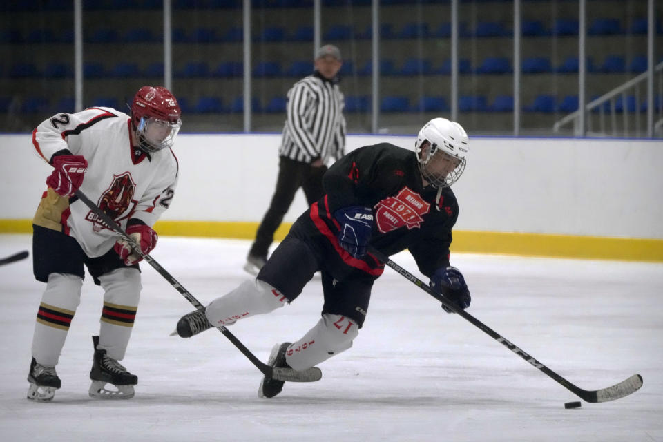 Members of the "1979" hockey club compete during a hockey match at a rink in Beijing, Wednesday, Jan. 12, 2022. Spurred by enthusiasm after China was awarded the 2022 Winter Olympics, the members of a 1970s-era youth hockey team, now around 60 years old, have reunited decades later to once again take to the ice. (AP Photo/Mark Schiefelbein)