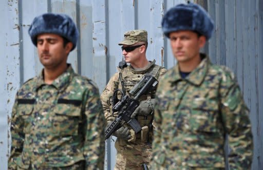 A US soldier (C) stands guard behind two Afghanistan Public Protection Forces (APPF) officers during a ceremony on the outskirts of Kabul