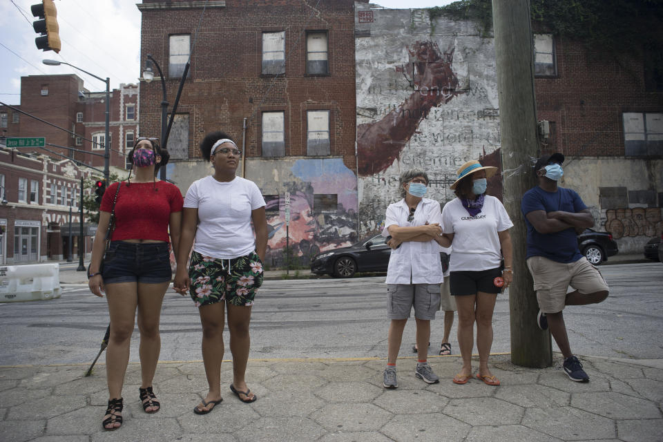 ATLANTA, July 19, 2020 -- People wearing face masks stand on a street in Atlanta, Georgia, the United States, July 19, 2020.   A study published on Tuesday shows that in people with mild COVID-19 cases, their antibodies against the coronavirus drop sharply over the first three months after infection. (Photo by Alan Chin/Xinhua via Getty) (Xinhua/ via Getty Images)