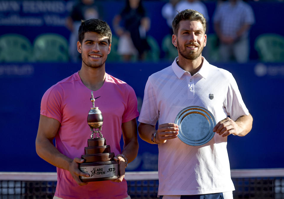 Carlos Alcaraz (pictured left) defeated Cameron Norrie (pictured right) hold their trophies.