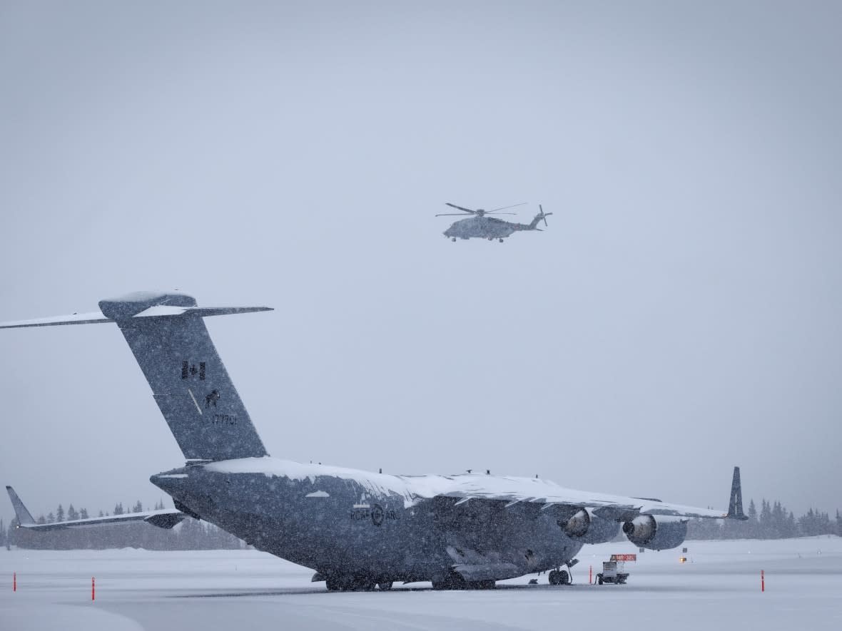 Military aircraft take part in a search for wreckage from an aerial object downed over Yukon at the Whitehorse airport on Monday. (Evan Mitsui/CBC - image credit)