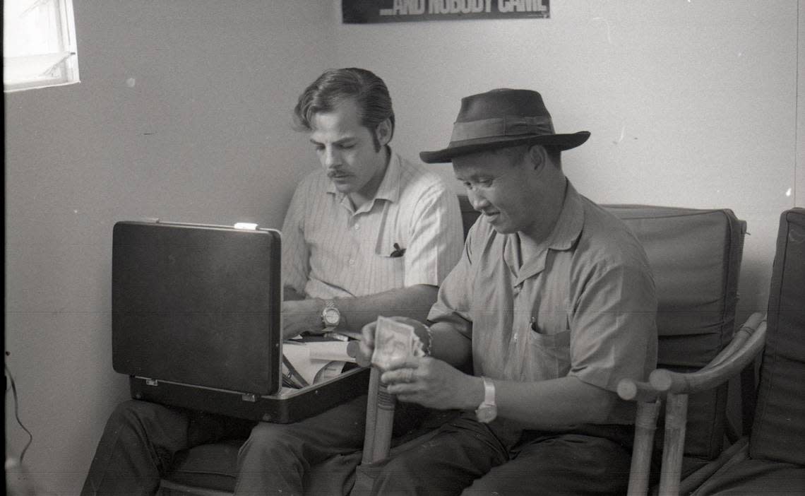 In this image, “USAID Personnel #12,” Galen Beery (USAID) is photographed working next to Naikhong Zueker Moua (USAID) in Ban Xon, Laos in 1971. https://omeka.library.fresnostate.edu/s/beery-legacy-exhibit/item/6762/Gifted by Galen Beery to Hmongstory Legacy, digital reproduction gifted to Fresno State.