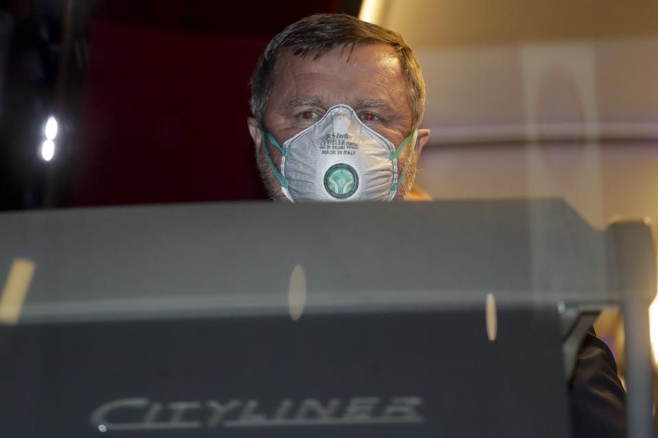 Bulgarian soccer team Ludogorets coach Pavel Vrba wears a protective face masks as he sits in the coach bus heading to the San Siro stadium, in Milan, Italy, Thursday, Feb. 27, 2020. Ludogorets is playing Italian club Inter Milan in a Europa League soccer match on Thursday that is scheduled to go ahead in an empty stadium due to the coronavirus outbreak. (AP Photo/Luca Bruno)