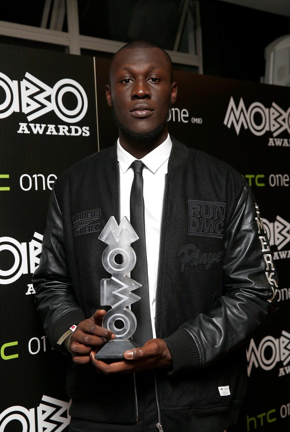 LONDON, ENGLAND - OCTOBER 22:  Stormzy poses with the MOBO award for Best Grime Act in the winners room at the MOBO Awards at SSE Arena on October 22, 2014 in London, England.  (Photo by Tristan Fewings/Getty Images)