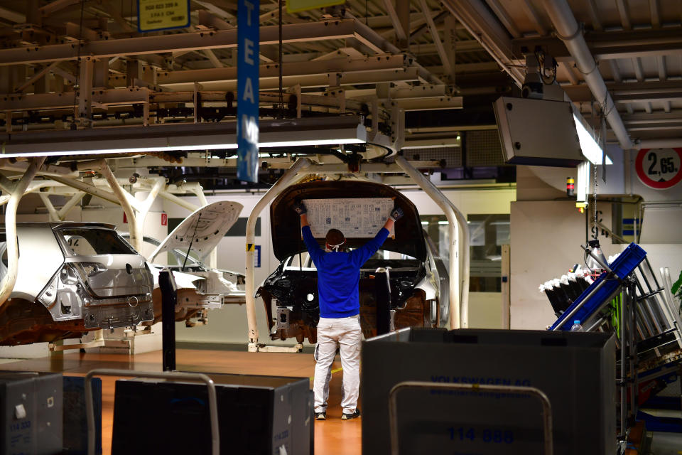 WOLFSBURG, GERMANY - APRIL 27: Workers wear face masks while working on the car assembly line on the first day of the resumption of automobile production at the Volkswagen factory during the coronavirus crisis on April 27, 2020 in Wolfsburg, Germany. Production was shut down in March due to both to lockdown measures designed to stem the spread of the virus and the breakdown of international supply chains. Germany is taking steps to lift lockdown measures in a careful attempt to get the economy back into gear. (Photo by Alexander Koerner/Getty Images)