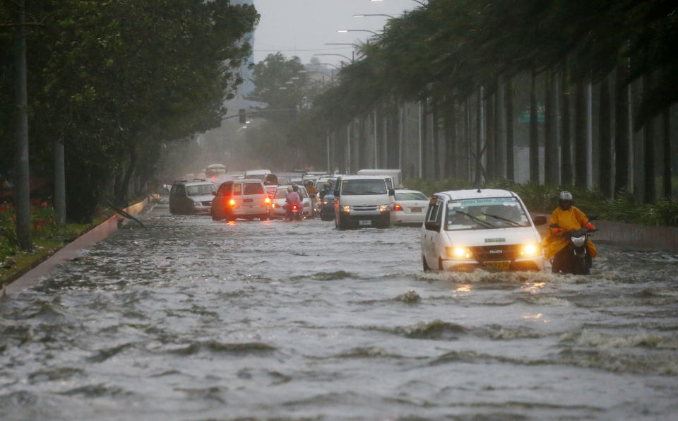 Motorists negotiate a flooded street following heavy rains and strong winds brought about by Typhoon Mangkhut which barreled into northeastern Philippines before dawn Saturday, Sept. 15, 2018 in Manila, Philippines. The typhoon slammed into the Philippines' northeastern coast early Saturday, its ferocious winds and blinding rain ripping off tin roof sheets and knocking out power, and plowed through the agricultural region at the start of the onslaught. (AP Photo/Bullit Marquez)