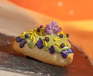 Mossberry Biscuit: Biscuit topped with ube and matcha icing, ube micro sponge cake, sprinkles, and dehydrated blueberries
