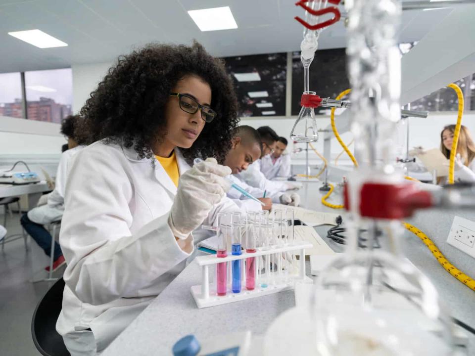 lab worker inspects test tubes