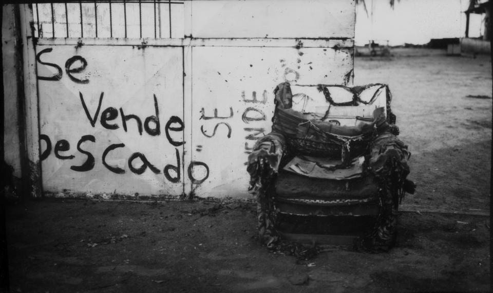 A damaged chair sits outside a fisherman's home that reads in Spanish "Fish for sale" in Cabimas, Venezuela, near oil-contaminated Lake Maracaibo. (Photo: Rodrigo Abd/AP)