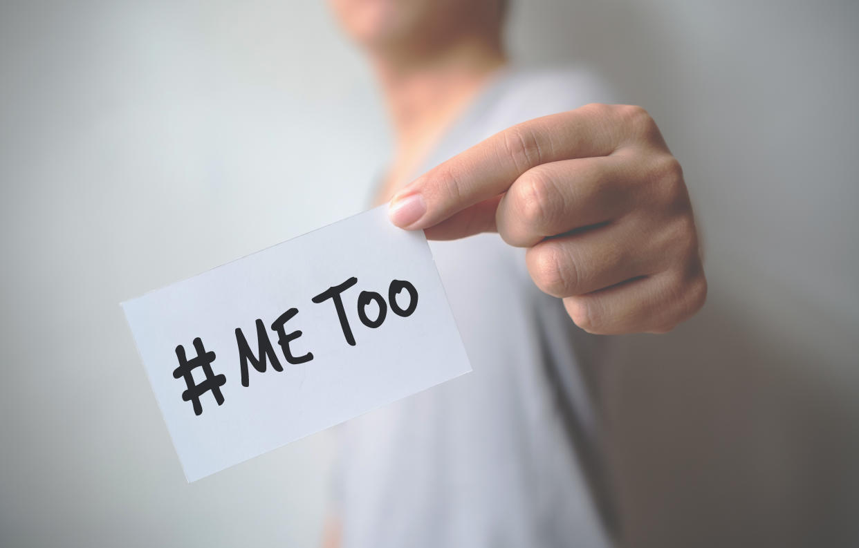 Close up hand of young man holding show a white card with word “Me Too”. Social movement concept