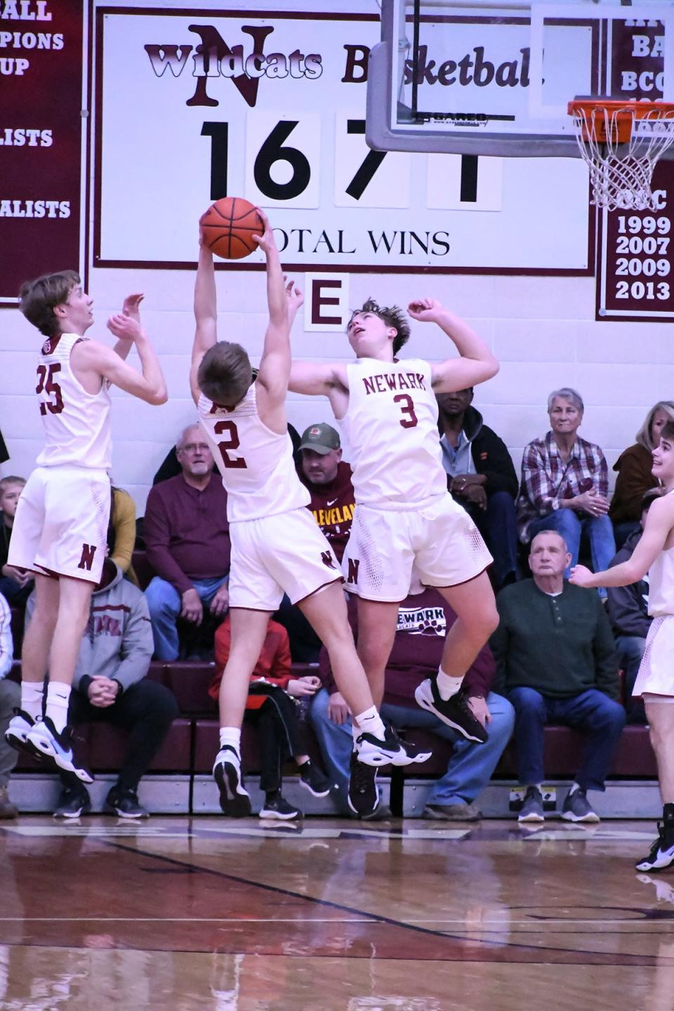 Newark junior Drew Oberholtzer (2) grabs a rebound between teammates senior Grant Somers (25) and sophomore Steele Meister (3) against Pickerington Central at Jimmy Allen Gymnasium on Friday, Jan. 21, 2022. The host Wildcats fell 54-42 in an Ohio Capital Conference-Buckeye Division showdown.