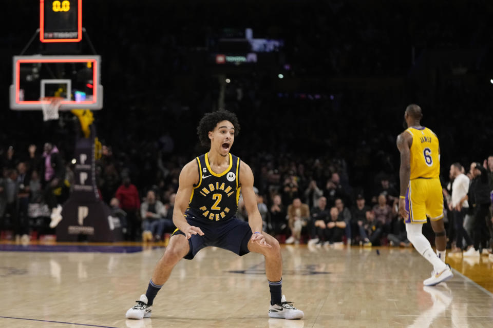 Indiana Pacers guard Andrew Nembhard, left, celebrates after making a buzzer beating 3-point shot to win the game as Los Angeles Lakers forward LeBron James stands in the background during the second half of an NBA basketball game Monday, Nov. 28, 2022, in Los Angeles. The Pacers won 116-115. (AP Photo/Mark J. Terrill)