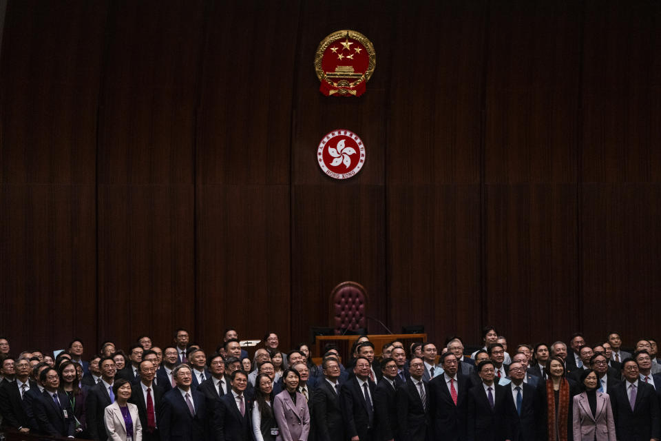 Hong Kong's Chief Executive John Lee, fifth foreground left, pose for photographs with lawmakers following the passing of the Basic Law Article 23 legislation at the Legislative Council in Hong Kong, Tuesday, March 19, 2024. (AP Photo/Louise Delmotte)