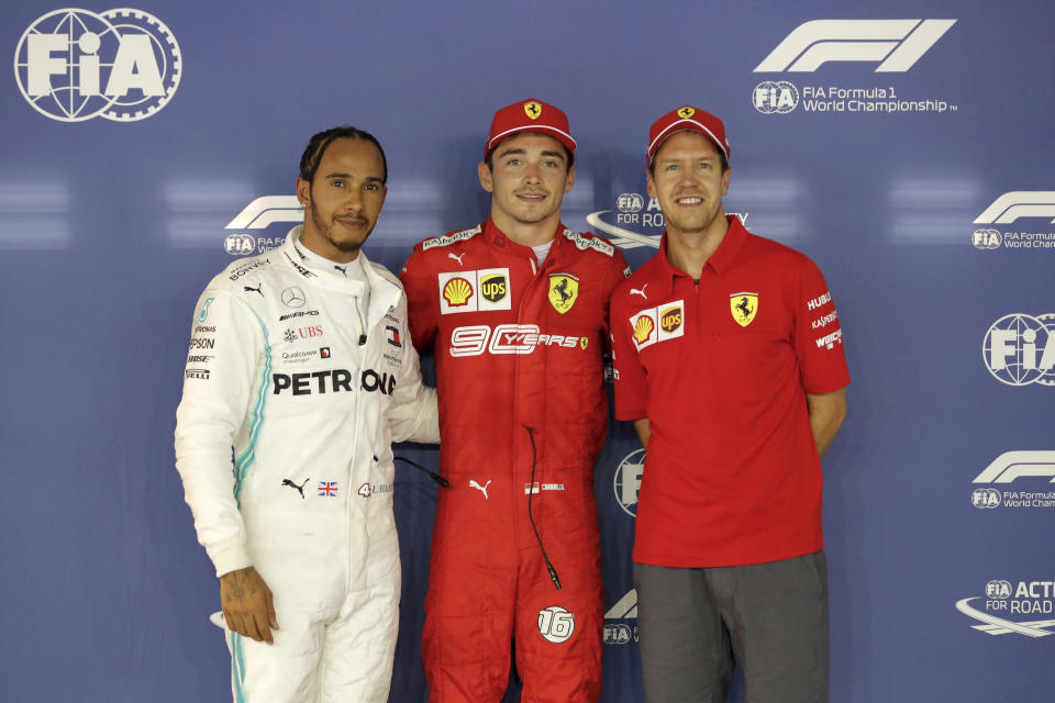 Ferrari driver Charles Leclerc of Monaco, center, poses with his teammate Sebastian Vettel of Germany, right, and Mercedes driver Lewis Hamilton of Britain after taking pole in the qualifying session for the Singapore Formula One Grand Prix at the Marina Bay City Circuit in Singapore, Saturday, Sept. 21, 2019. Hamilton finished second as Vettel was third. (AP Photo/Vincent Thian)