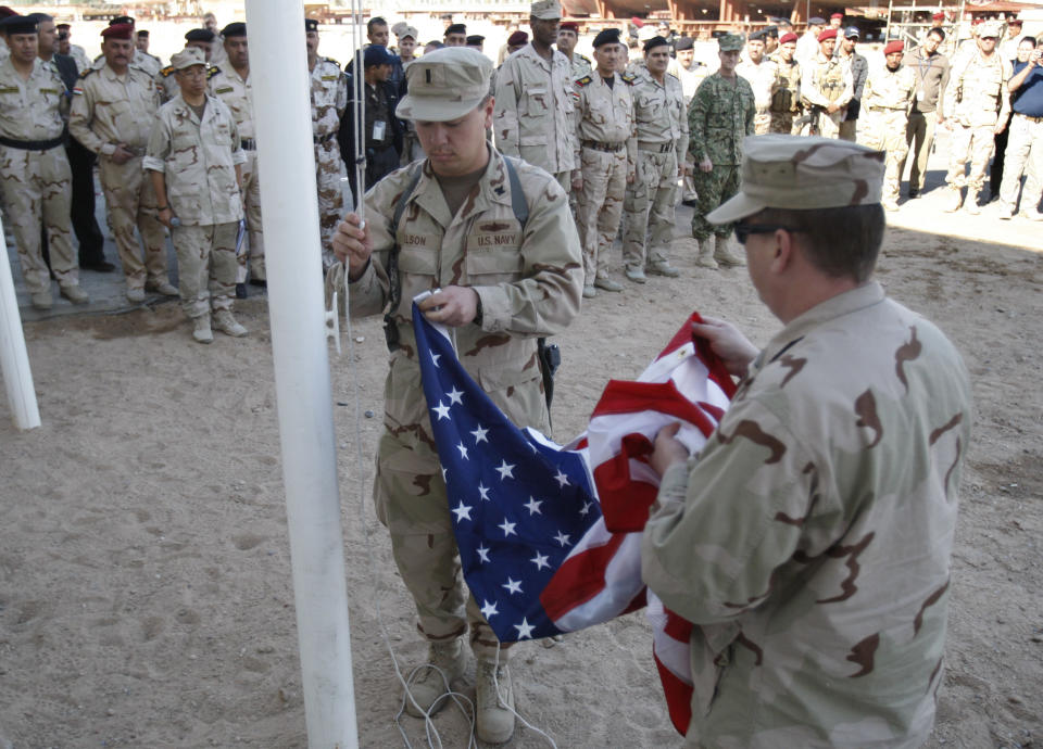 FILE - In this Dec. 1, 2011, file photo, U.S. servicemen fold the American flag after it was lowered during the a handover ceremony of a military base in Basra, Iraq. A burst of strength by al-Qaida that is chipping away at the remains of Mideast stability now confronts President Barack Obama and is testing his hands-off approach to conflicts in Iraq and Syria at the same time he pushes to keep thousands of U.S. forces in Afghanistan. he U.S. withdrawal at the end of 2011 was followed by a spike in sectarian violence and most recently, the alarming takeover of two cities by an al-Qaida affiliate known as the Islamic State of Iraq and the Levant. (AP Photo/Nabil al-Jurani)