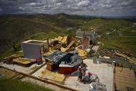 <p>Rafael Reyes embraces his wife Xarelis Negron and his son Xariel as they stand next to thier belongings, in front of the remains of their home destroyed by Hurricane Maria, in the San Lorenzo neighborhood of Morovis, Puerto Rico, Saturday, Oct. 7, 2017. The Reyes family lost all their belongings and their house, and are looking forward to being able to rebuild and continue their life. (Photo: Ramon Espinosa/AP) </p>