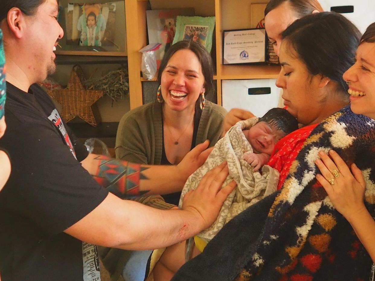 The grant could help doula and lactation consultant Camie Goldhammer amplify her work of supporting Native mothers and their babies. Goldhammer (center), a member of Sisseton Wahpeton Oyate, is shown here with Mom/Iná Alayna Eagleshield (Standing Rock) and Dad/Até (Three Affiliated Tribes) and aunties as they  welcome new bébela Wingmuke Wakhangli Win after their home birth in Seattle.  (Photo/ Rae Pairs)