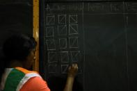 Official tallies the ballots on a chalkboard during the presidential election in Abidjan