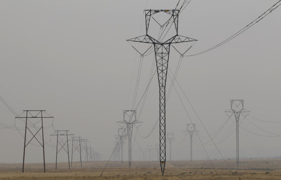 FILE - Power transmission lines are seen in New Mexico near the Apache-Sitgreaves National Forest, Wednesday, June 8, 2011. The death of an older Arizona woman when her electricity was cut during a heat spell five years ago spurred changes in shutoff rules. The Arizona agency that oversees regulated utilities now bans power companies from cutting off power for failure to pay during Arizona's hottest months. (AP Photo/Jae C. Hong, File)