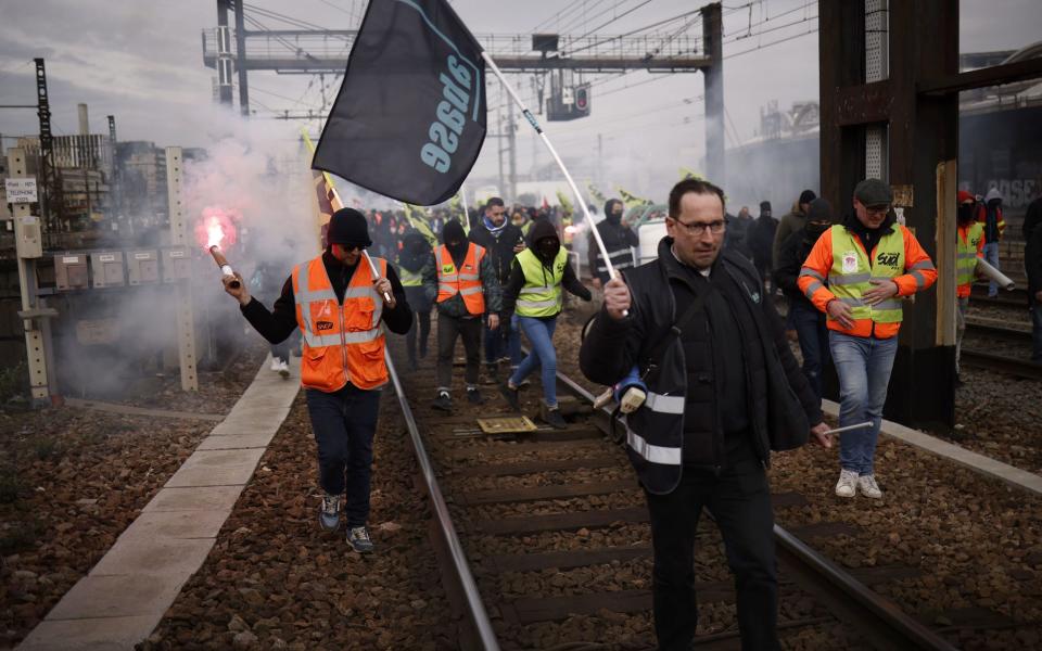 Protestors walk on rails and light flares at the Gare de Lyon station - YOAN VALAT/EPA-EFE/Shutterstock