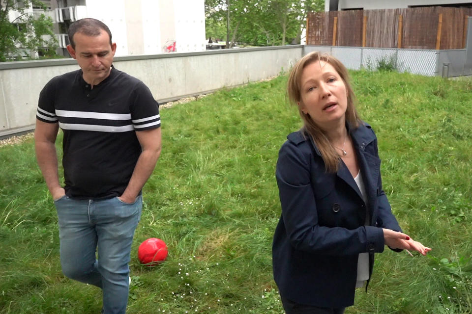 In this image from TV taken Thursday April 30, 2020 France's Cecile Bardin,40, and Britain's Frederic Pruvost, 49, walk in a garden in Paris. Cécile and Frederic are parents of two children Hugo and Alex and decided not to send their children back to school from May 11th. As France reopens schools despite fears of new virus infections, parents around the country are deeply torn, asking themselves: Should I send my child back to school? Can I afford not to? (AP Photo/Nicolas Garriga)