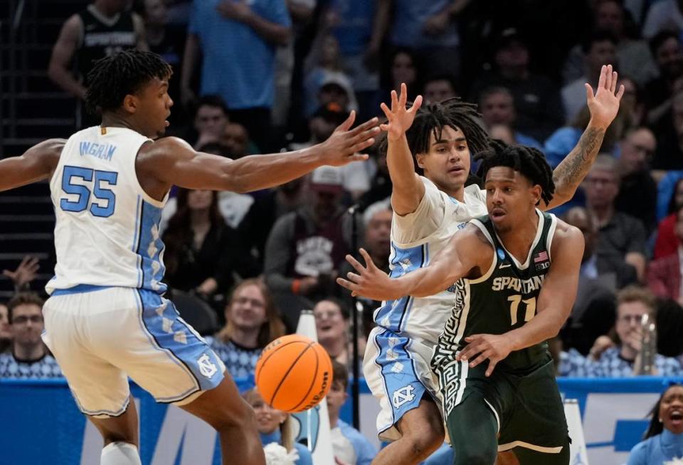 Michigan State Spartans guard A.J. Hoggard (11) passes away from North Carolina Tar Heels forward Harrison Ingram (55) and North Carolina Tar Heels guard Elliot Cadeau (2) in the second round of the NCAA Tournament at the Spectrum Center. Bob Donnan-USA TODAY Sports