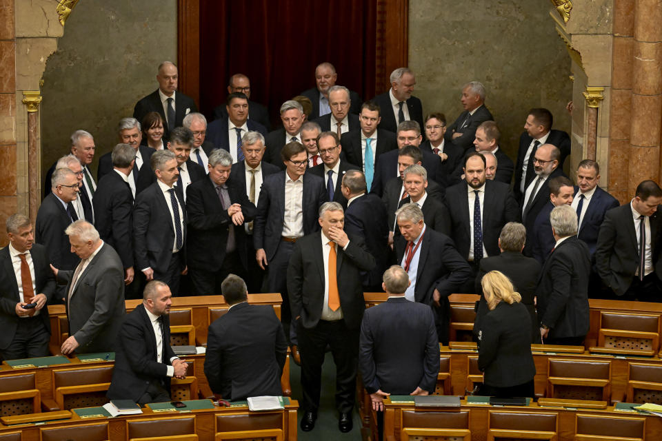 Lawmakers stand around Hungarian Prime Minister Viktor Orban before Tamas Sulyok's swearing in as the country's new President in a parliament session, in Budapest, Hungary, Monday, Feb 26, 2024. Hungary's former president, Katalin Novak, stepped down in February, over a pardon she issued to an accomplice in a child sexual abuse case.(AP Photo/Denes Erdos)