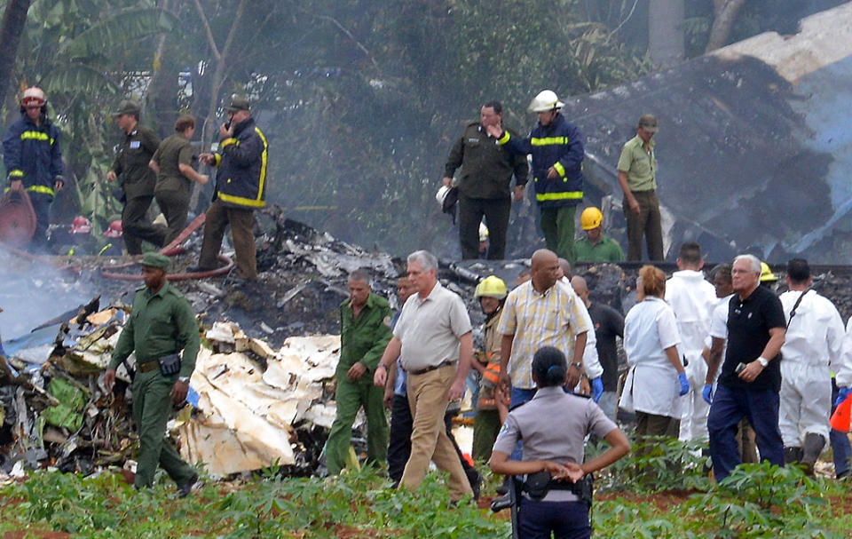 <p>Cuban President Miguel Diaz-Canel (C) is pictured at the site of the accident after a Cubana de Aviacion aircraft crashed after taking off from Havana’s Jose Marti airport on May 18, 2018. – A Cuban state airways passenger plane with 113 people on board crashed on shortly after taking off from Havana’s airport, state media reported. The Boeing 737 operated by Cubana de Aviacion crashed “near the international airport,” state agency Prensa Latina reported. Airport sources said the jetliner was heading from the capital to the eastern city of Holguin. (Photo: Adalberto Roque/AFP/Getty Images) </p>