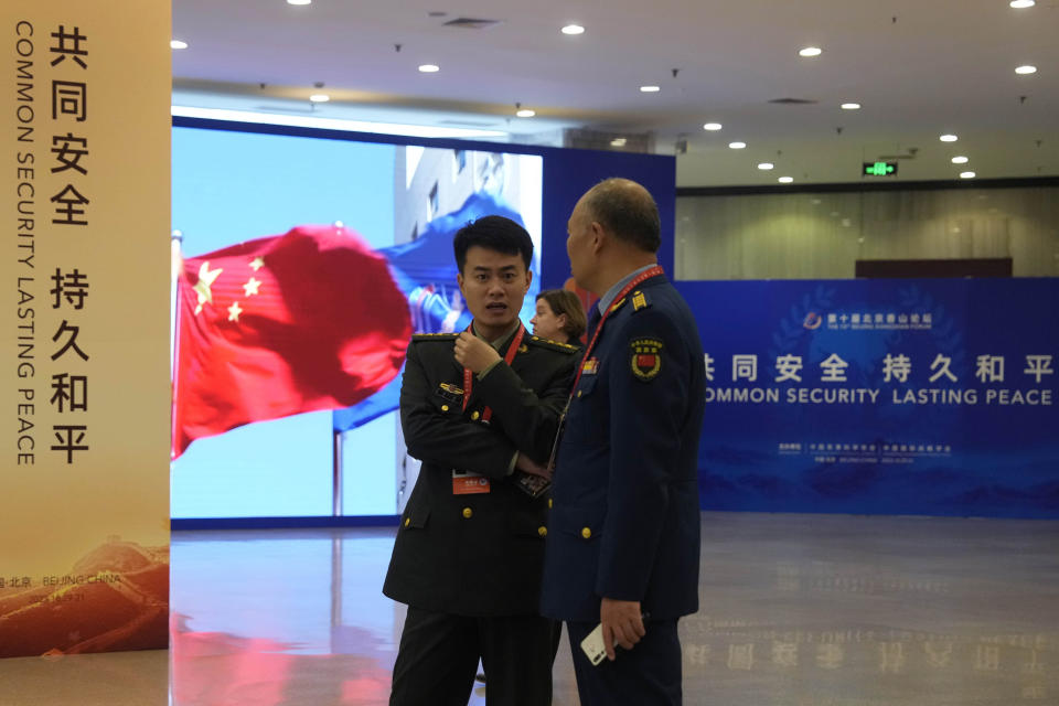 Chinese military officers stand near the slogan "Common Security, Lasting Peace" for the 10th Beijing Xiangshan Forum held in Beijing, Monday, Oct. 30, 2023. China suspended military communication with the U.S. in August 2022 to show its displeasure over a visit by former U.S. House Speaker Nancy Pelosi to self-ruled Taiwan, which Beijing considers part of its territory. (AP Photo/Ng Han Guan)