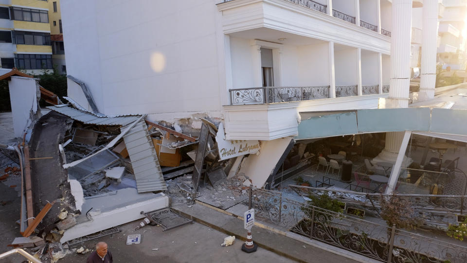 A man passes next to a damaged building after a magnitude 6.4 earthquake in Durres, western Albania, Tuesday, Nov. 26, 2019. (Photo: Hektor Pustina/AP)