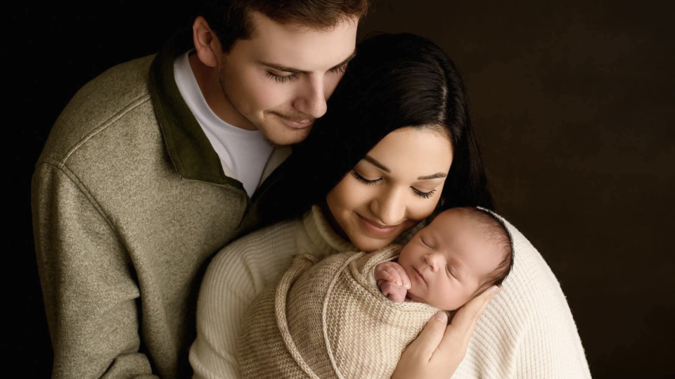 Hunter and Alexis Wilkes holding their newborn. 