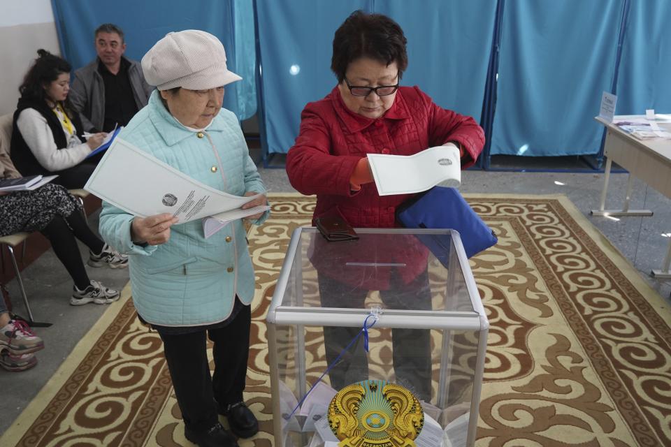 Two women cast their ballots at a polling station in Almaty, Kazakhstan, Sunday, March 19, 2023. Voters in Kazakhstan cast ballots on Sunday after a short but active campaign for seats in the lower house of parliament that is being reconfigured in the wake of deadly unrest that gripped the resource-rich Central Asian nation a year ago. (Vladimir Tretyakov/NUR.KZ via AP)