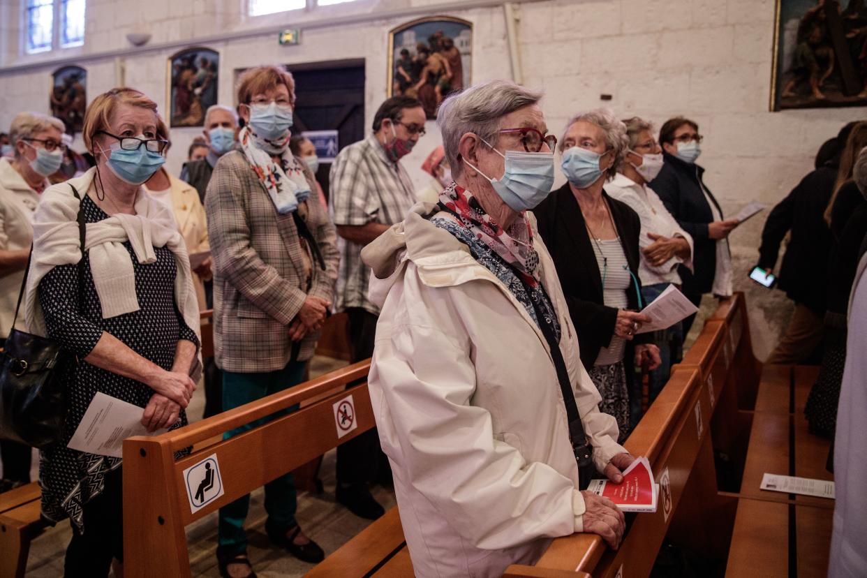 Catholic worshippers wear face masks as they attend a mass in the Church of Saint-Etienne in the city of Saint-Etienne-du-Rouvray in France. (Sameer Al-Doumy/AFP via Getty Images)