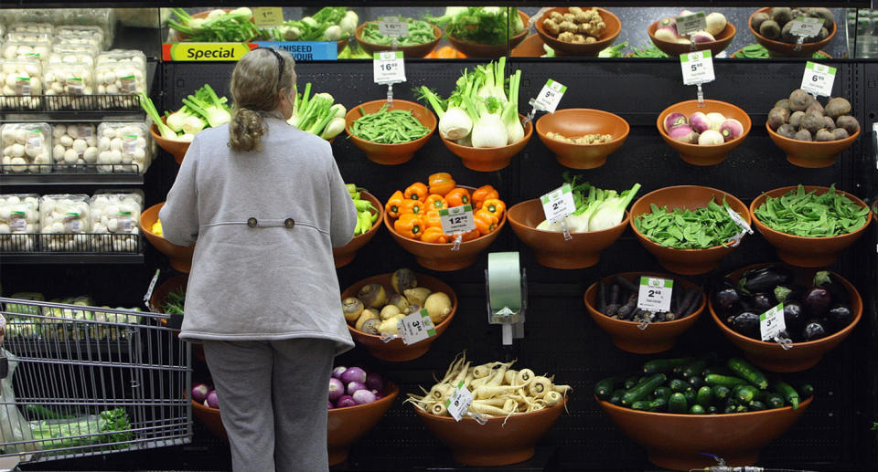 Woman standing in supermarket looking at fresh produce