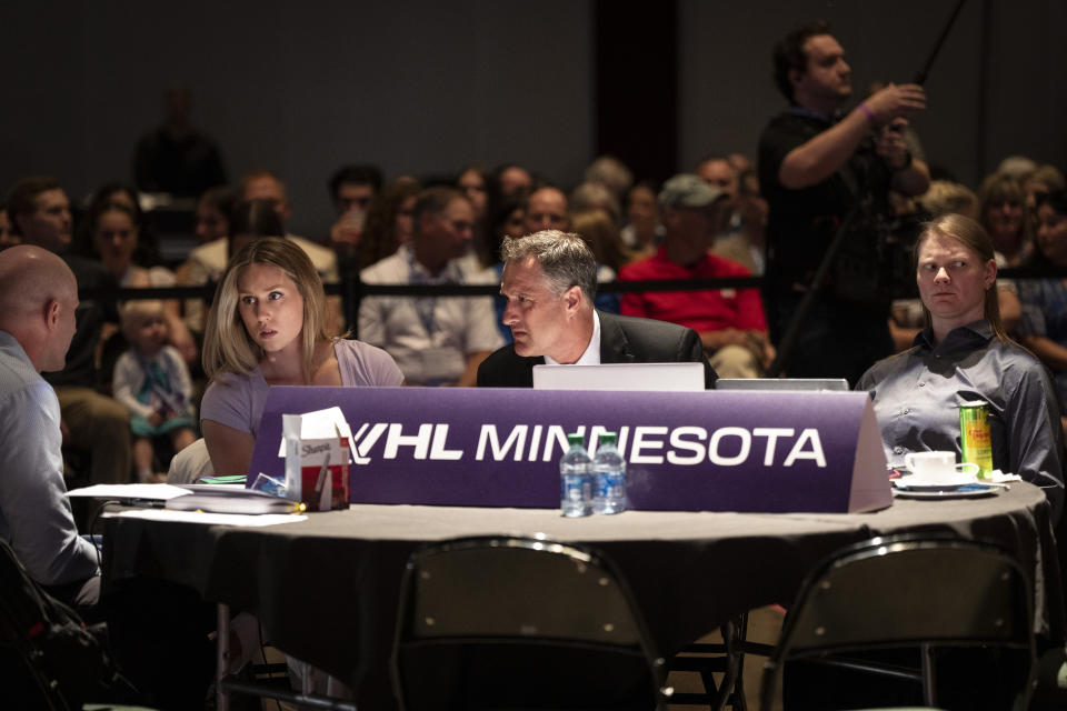 Minnesota head coach Ken Klee, center, talks with other people at the Minnesota table before their first pick during the PWHL hockey draft in St. Paul, Minn., Monday June, 10, 2024. (Renée Jones Schneider/Star Tribune via AP)