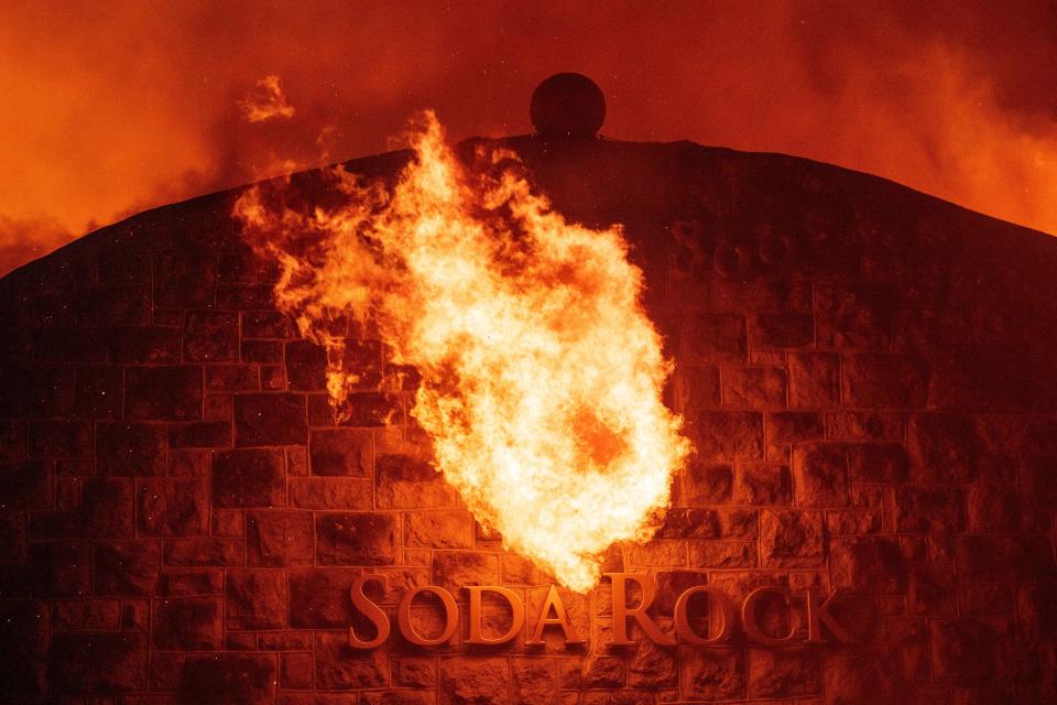 Flames shoot out a window as the Soda Rock Winery burns during the Kincade fire as flames race through Healdsburg, California on October 27, 2019. - Powerful winds were fanning wildfires in northern California in "potentially historic fire" conditions, authorities said October 27, as tens of thousands of people were ordered to evacuate and sweeping power cuts began in the US state. (Photo by Josh Edelson / AFP) (Photo by JOSH EDELSON/AFP via Getty Images)
